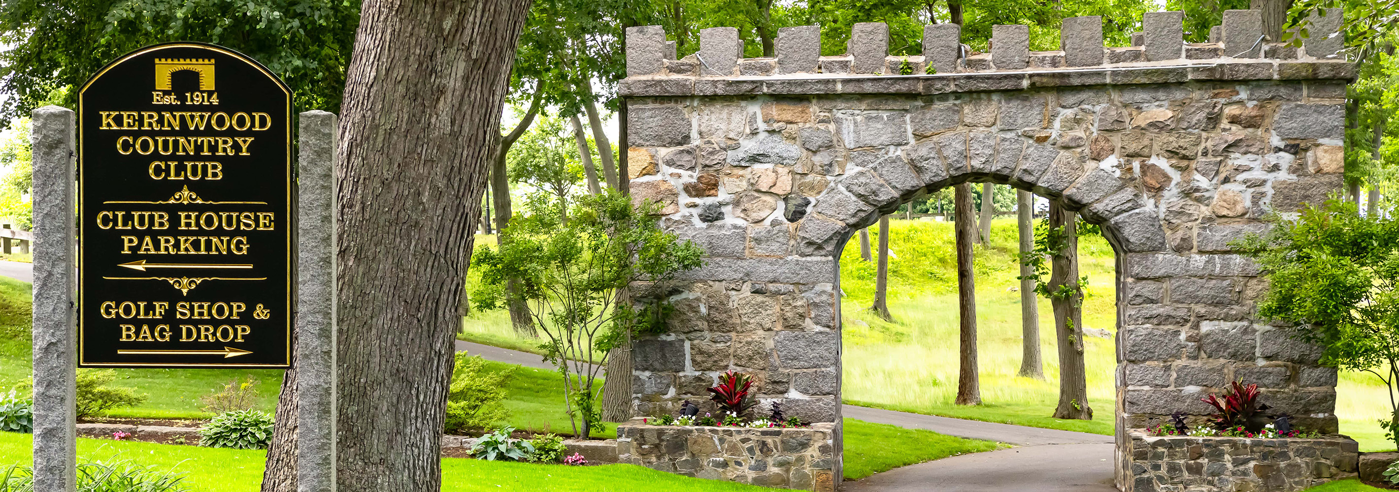 The Est. 1914 castellated stone arch at the entrance to Kernwood Country Club in Salem, Massachusetts
